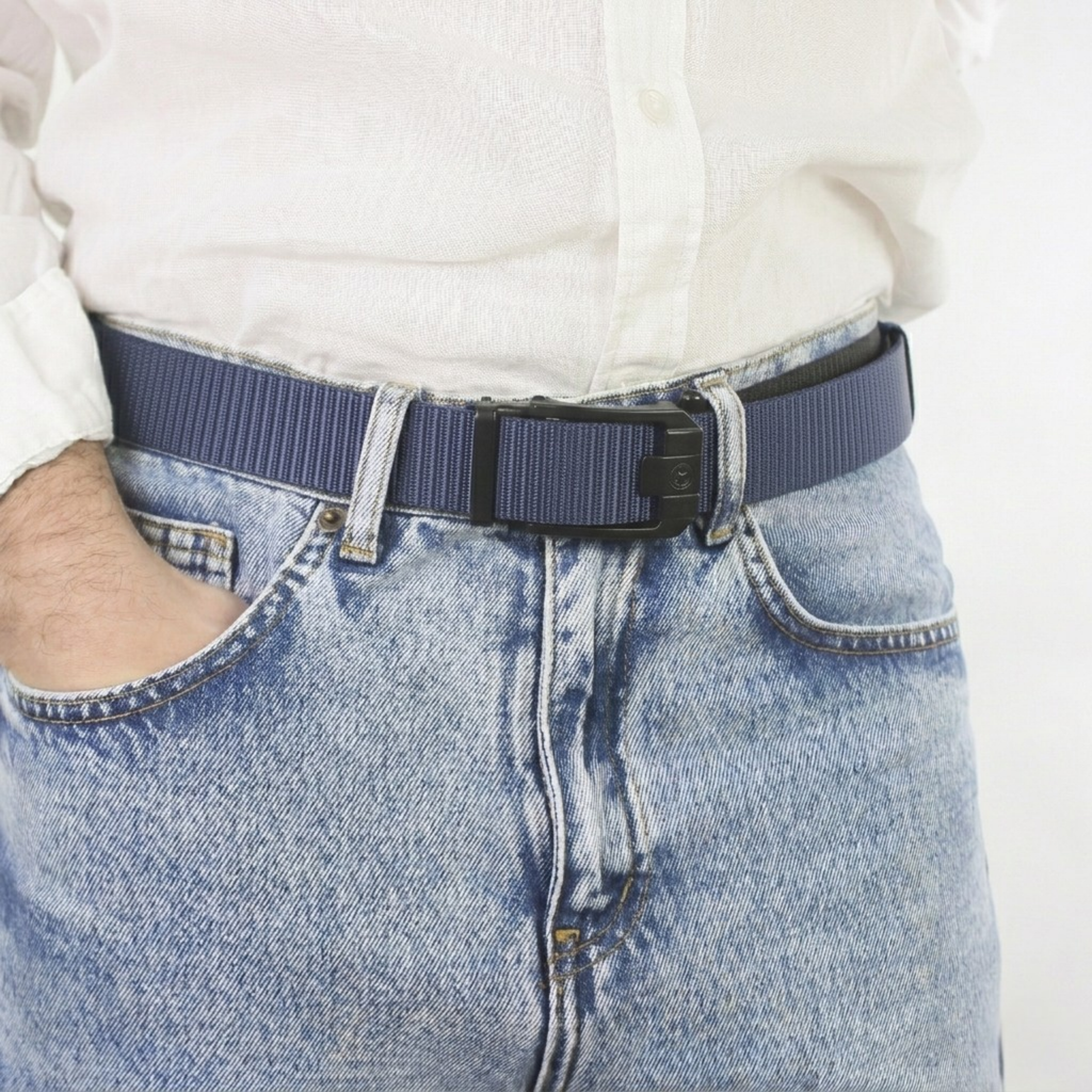 A close-up view of a man wearing a navy blue web belt with a black sliding buckle, paired with a white shirt and light blue denim jeans.